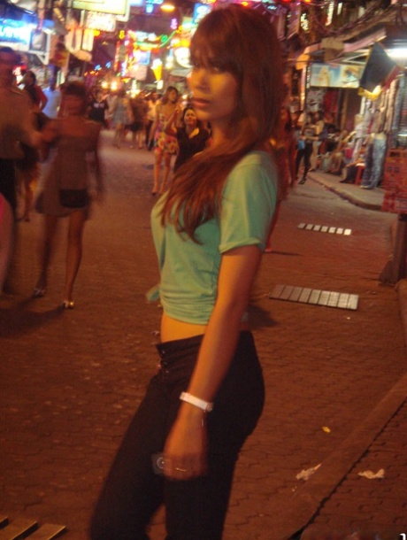 Tourist during walk on night streets takes photos of various ladyboys