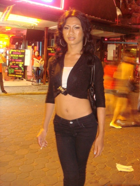 Tourist during walk on night streets takes photos of various ladyboys