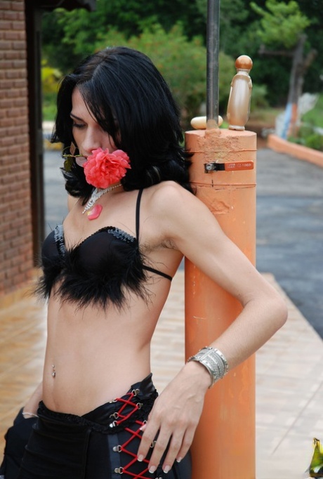 Raven-haired shemale Marcia Kelly sucking her own dick outdoors